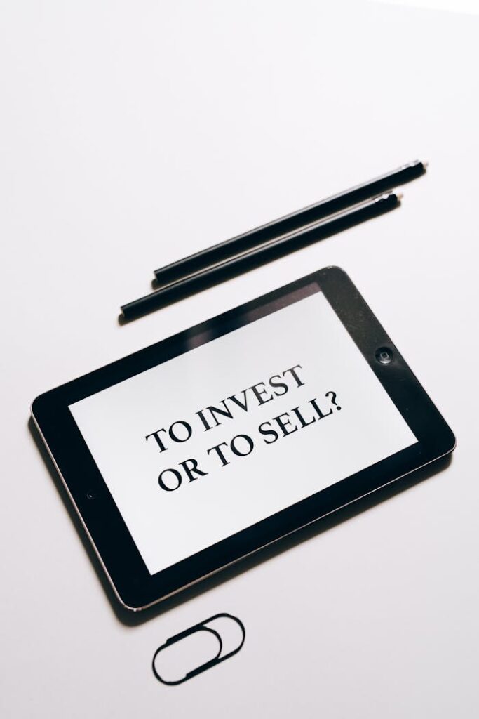 Tablet displaying 'To Invest or To Sell?' question, symbolizing investment decisions.